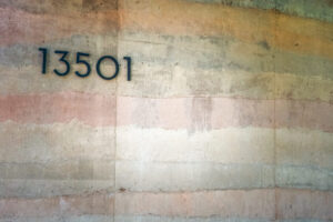 A photo of a rammed earth construction wall with home address.